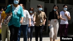 People wearing face masks cross a road, amid the coronavirus disease (COVID-19) Omicron wave in Singapore