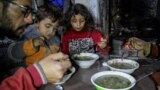 Displaced Palestinian man Wael Al-Attar eats Khobiza, a wild leafy vegetable, with his family as they break their fast during the holy month of Ramadan, at a school where they shelter, in Jabalia in the northern Gaza Strip, March 22, 2024. (REUTERS/Mahmoud Issa)