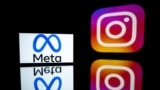 FILE - This photograph taken on Jan. 12, 2023, shows a smartphone and a computer screen displaying the reflected logos of Instagram app and its parent company Meta in Toulouse, south-western France.