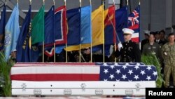 FILE - An honor guard signals a command as caskets containing the remains of American servicemen from the Korean War handed over by North Korea arrive at Joint Base Pearl Harbor-Hickam in Honolulu, Hawaii, U.S., Aug. 1, 2018.