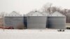 Utility workers travel by boat past grain bins in the flooded town of Pacific Junction, Iowa, April 3, 2019. 