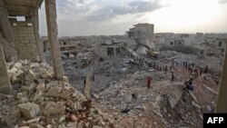 Syrians gather amidst destruction in Zardana, in the mostly rebel-held northern Syrian Idlib province, in the aftermath of airstrikes in the area, June 8, 2018.