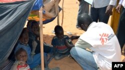 Un employé de MSF examine des enfants souffrant de malnutrition dans un camp de réfugiés maliens situé à Chinegodar, dans l'ouest du Niger, près de la frontière malienne, le 4 février 2012.