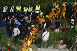 Rescue workers go through a shift change at the derailed train near the Taroko Gorge area in Hualien, Taiwan, April 2, 2021.