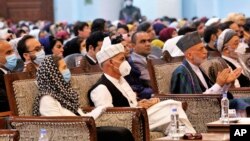 Afghan President Ashraf Ghani, center left, wears a protective face mask to help curb the spread of the coronavirus, on the last day of an Afghan Loya Jirga or traditional council, in Kabul, Afghanistan, Aug. 9, 2020. 