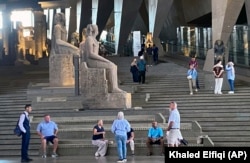 Visitors walk past ancient Egyptian colossal statues along the Grand Staircase at the Grand Egyptian Museum in Giza, Egypt, Tuesday, Oct.15, 2024. (AP Photo/Khaled Elfiqi)