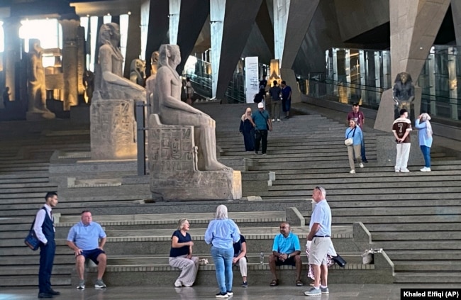 Visitors walk past ancient Egyptian colossal statues along the Grand Staircase at the Grand Egyptian Museum in Giza, Egypt, Tuesday, Oct.15, 2024. (AP Photo/Khaled Elfiqi)