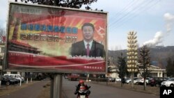 FILE - A billboard shows Chinese President Xi Jinping with the slogan, "To exactly solve the problem of corruption, we must hit both flies and tigers," in Gujiao, in northern China's Shanxi province, Feb. 6, 2015.