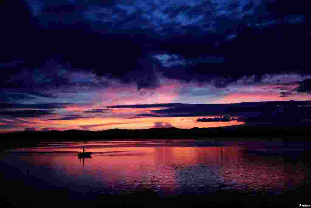 A man fishes on a boat at Lake Hamana in Hamamatsu, Shizuoka Prefecture, Japan.