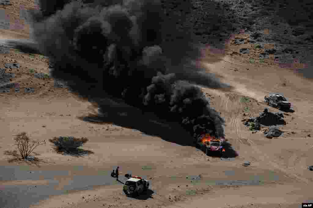The car of driver Dumas Romain and co-driver Winocq Alexandre of France burns during stage one of the Dakar Rally, between Jiddah and Al Wajh, Saudi Arabia.
