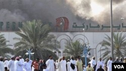 Warga Oman menyaksikan asap mengepul dari sebuah toserba di Sohar, Senin (28/2).