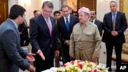 U.S. Defense Secretary Ash Carter gestures to the guest book he just signed as he stand with Kurdish regional government President Massoud Barzani at the White House in Irbil, Iraq, July 24, 2015. 