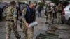 Policajac nosi kutiju sa antipešadijskom minom u gradu Zoločiv