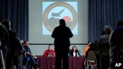 U.S. Interior Secretary Deb Haaland and Assistant Secretary Bryan Newland listen as April Hiosik Ignacio, center, speaks of her grandmother's time in an Indian boarding school, Friday, Jan. 20, 2023, at the Gila Crossing Community School in Laveen, Ariz.