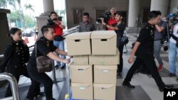 FILE - Anti-corruption agency's staff transport documents for the 1MDB case to Kuala Lumpur high court, in Kuala Lumpur, Malaysia, Aug. 28, 2019. The investigation into one of the world's biggest corruption scandals has now been thrown into uncertainty. 