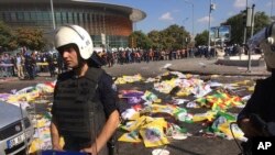 Jenazah korban bom ditutup dengan bendera dan spanduk sementara polisi mengamankan lokasi setelah terjadi insiden ledakan di Ankara, Turki (10/10).