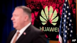 A monitor displays the logo for "Huawei" behind Secretary of State Mike Pompeo as he speaks during a news conference at the State Department in Washington, Wednesday, July 15, 2020. (AP Photo/Andrew Harnik, Pool)