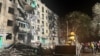 FILE - In this photo released by Ukraine's National Police, onlookers gather after a Russian strike on a residential building in Kharkiv, Ukraine, Oct. 2, 2024. A U.N. report issued on Jan. 8, 2025, accuses Russia of carrying out a policy of mass destruction against Ukraine.