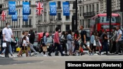 FILE PHOTO: People walk at Oxford Circus, as the spread of the coronavirus disease (COVID-19) continues, in London, Britain July 24, 2020.