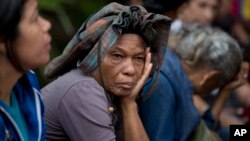 Adelaida Ospina shades herself with her bag as she waits in line outside a supermarket to buy food in Caracas, Venezuela, May 3, 2016.