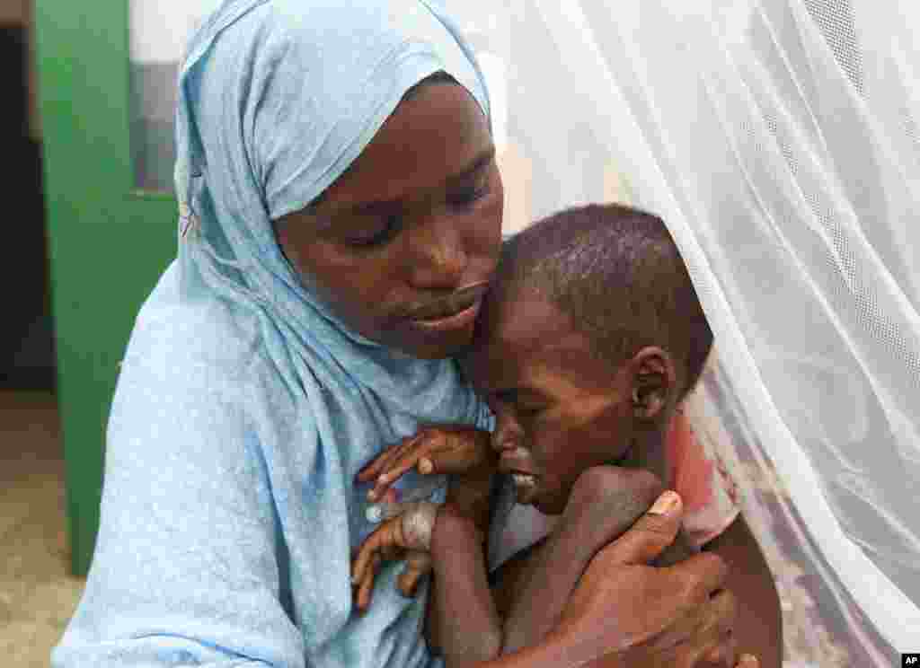 A handout picture taken July 26, 2011 and made available to Reuters on August 8, 2011, shows a Somali woman holding her malnourished child at the Banadir hospital in southern Mogadishu.   (Reuters/IHH Humanitarian Relief Foundation)