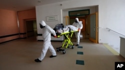 Health care workers transport a COVID-19 patient from an intensive care unit (ICU) at a hospital in Kyjov to a hospital in Brno, Czech Republic, Thursday, Oct. 22, 2020. Coronavirus infections in the Czech Republic are on a steep rise, setting a new records