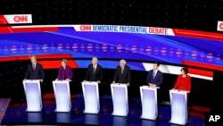 Democratic presidential candidates stand on stage during a Democratic presidential primary debate hosted by CNN and the Des Moines Register in Des Moines, Iowa, Jan. 14, 2020. 