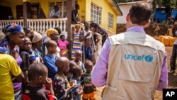 A UNICEF aid worker visits a home in Freetown, Sierra Leone, that was quarantined for 21 days because of the Ebola virus, Feb. 26, 2015.