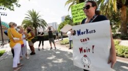 A small group of demonstrators gathers at Lake Eola Park to protest the Florida unemployment benefits system, June 10, 2020, in Orlando, Fla.