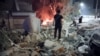 FILE - People gather at the site of a reported Israeli airstrike on the outskirts of Syria's capital Damascus, Oct. 8, 2024. After an Israeli strike on an apartment Nov. 10 belonging to the Lebanese armed group Hezbollah, Iran called for Israel's expulsion from the U.N. 