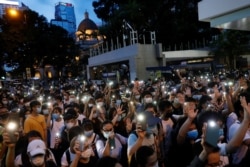 Pro-democracy demonstrators march holding their phones with flashlights on during a protest to mark the first anniversary of a mass rally against the now-withdrawn extradition bill, in Hong Kong, China June 9, 2020. REUTERS/Tyrone Siu