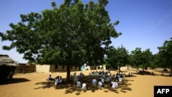 Des étudiants assistent à une classe à l'ombre d'un arbre dans le camp de personnes déplacées d'Abu Shouk, près d'El Fasher, la capitale du Darfour-Nord, le 6 septembre 2016.