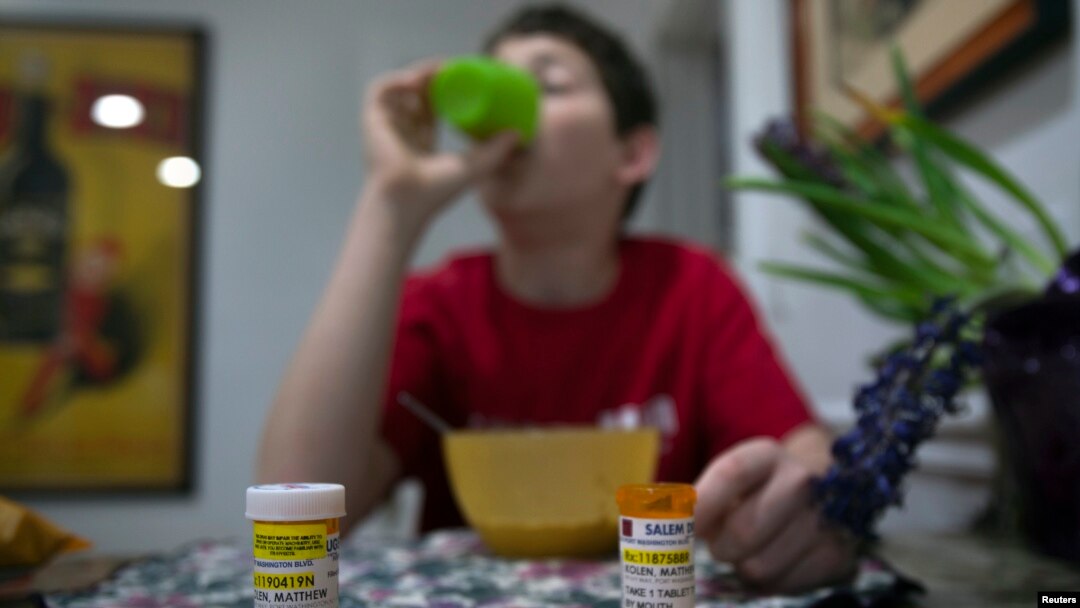 A youngster diagnosed at age eight with Asperger's syndrome takes medication with his breakfast at home on Long Island, New York, March 30, 2012.