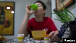 A youngster diagnosed at age eight with Asperger's syndrome takes medication with his breakfast at home on Long Island, New York, March 30, 2012.