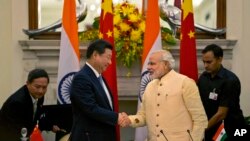 Presiden China Xi Jinping berjabat tangan dengan Perdana Menteri India, Narendra Modi, dalam pertemuan di New Delhi, September 2014. (AP/Manish Swarup)