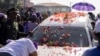 A woman cries as she leans on the hearse containing the coffin of late Suriname President Desi Bouterse during his funeral procession in downtown Paramaribo on Jan. 4, 2025. 