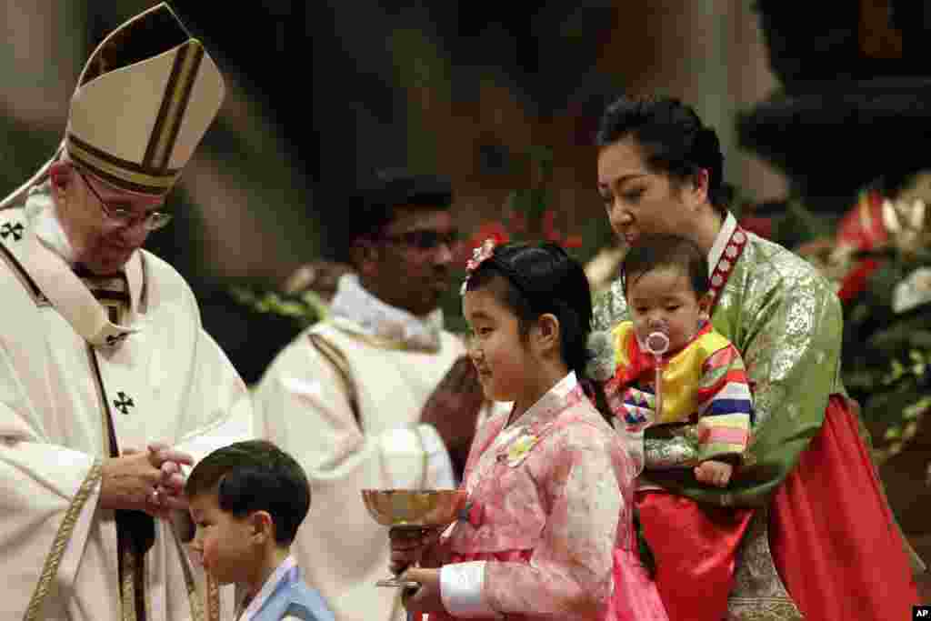 Faithful walk past Pope Francis during the Christmas Eve Mass celebrated in St. Peter&#39;s Basilica at the Vatican, Dec. 24, 2016.