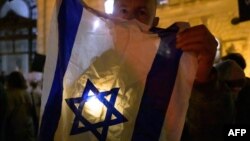 (FILE) A participant poses with a flag of Israel and a light.