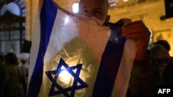 Seorang peserta demo anti-Semitisme di Wina, Austria, menunjukkan bendera Israel, 9 November 2023. (Foto: Joe Klamar/AFP)