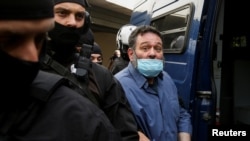 Greek Member of the European Parliament and former member of Golden Dawn Ioannis Lagos is escorted by anti-terrorism police officers as he enters a vehicle while leaving the prosecutor's office in Athens, Greece, May 15, 2021. 