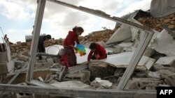 Des enfants palestiniens dans les décombres de leur maison démolie par des bulldozers israéliens dans une zone militaire contestée à Musafir Jenbah au sud d'Hébron en Cisjordanie, le 2 Février 2016.(Photo AFP/Hazem Bader)