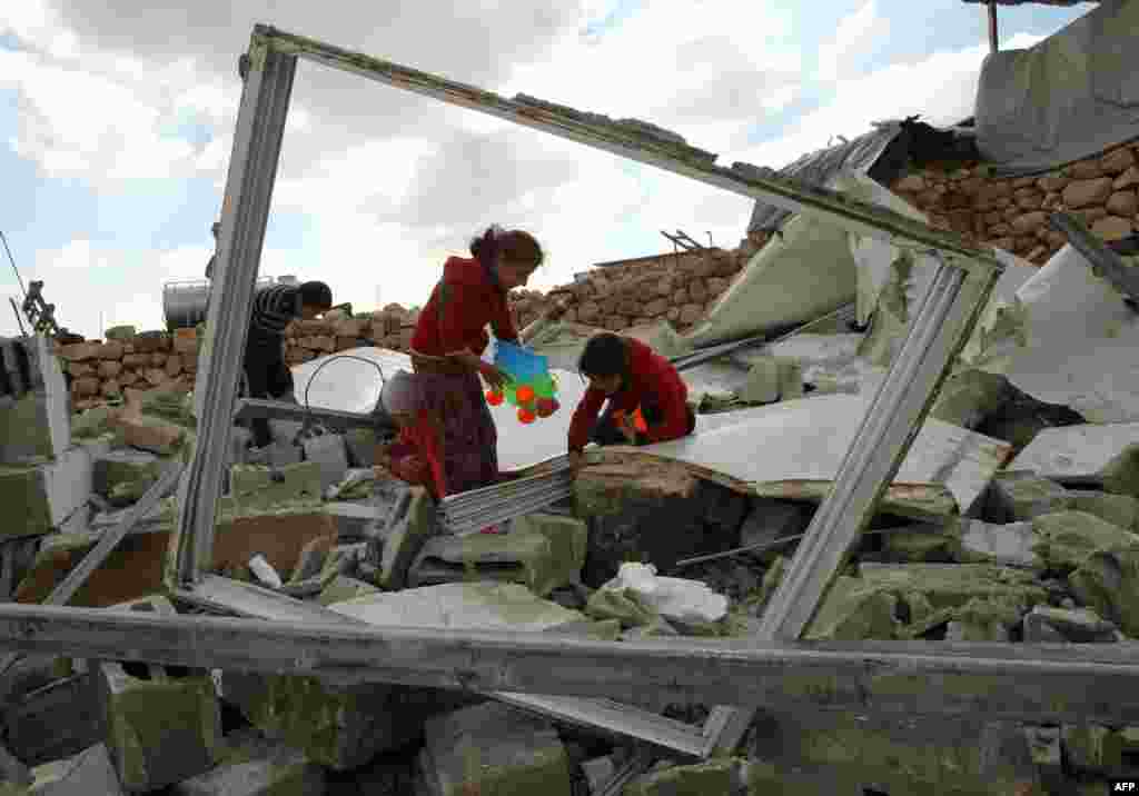 Palestinian children search for toys in the remains of their home after it was demolished by Israeli bulldozers in a disputed military zone in the area of Musafir Jenbah, south of the West Bank town of Hebron. Israeli forces demolished at least a dozen buildings in a disputed military zone in the southern West Bank, leaving a number of families homeless, authorities and residents said.