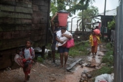 Personas cargan sus pertenencias mientras se dirigen a un refugio cuando el huracán Iota se acercaba a Puerto Cabezas, Nicaragua, 16 de noviembre de 2020.