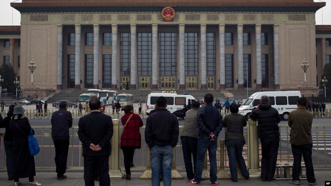 北京天安门广场上的人们观察警察在人民大会堂检查访问者（2013年11月9日）