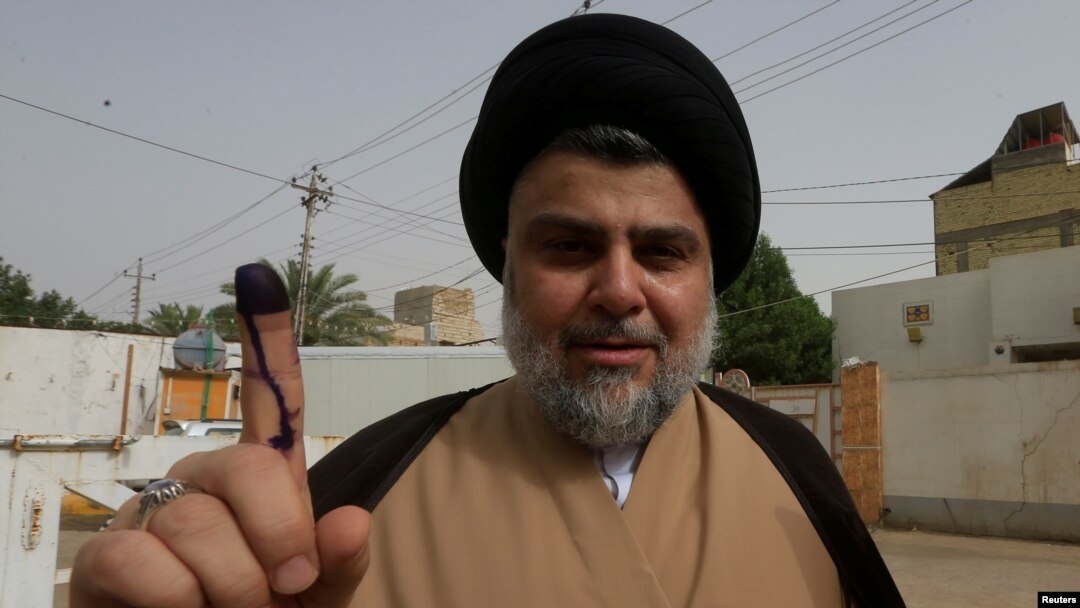 Ulama Shiah yang populis, Moqtada al-Sadr menunjukkan jarinya yang sudah dicelupkan tinta seusai memberikan suara di sebuah TPS di Najaf, Irak, 12 Mei 2018. (Foto: dok). 