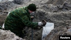 Một binh sĩ đào bới tìm kiếm hài cốt trong một ngôi mộ tập thể vốn từng nằm trong một khu ghetto người Do Thái thời Đức quốc xã ở trung tâm thành phố Brest, Belarus, ngày 26 tháng 2, 2019.