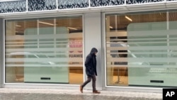 A man walks by the headquarters of Huawei in Brussels on March 13, 2025. Media reports say Huawei may be implicated in a Belgian corruption probe.