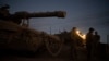 FILE - Israeli soldiers stand next to a tank in an area of the Israeli-annexed Golan Heights, Sept. 19, 2024.