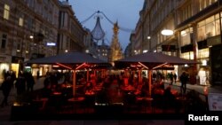 FILE - People sit in a cafe amidst the coronavirus disease (COVID-19) outbreak, in Vienna, Austria, Nov. 12, 2021. 