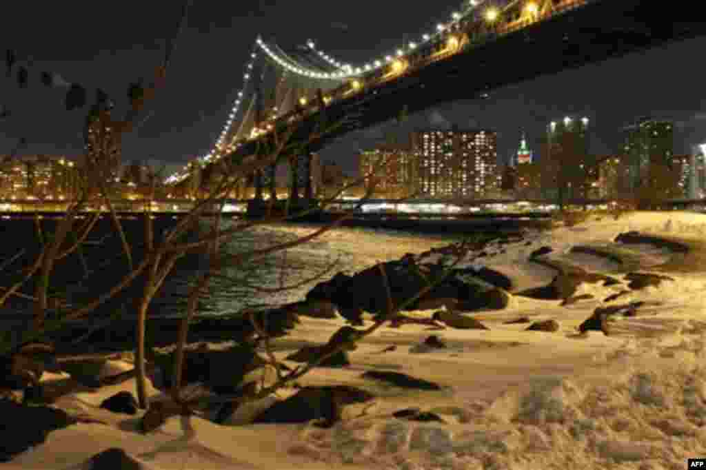 The Manhattan Bridge illuminates the night sky as seen from a park in the Dumbo neighborhood of the Brooklyn Borough of New York, Monday Dec. 27, 2010. (AP Photo/James H. Collins)